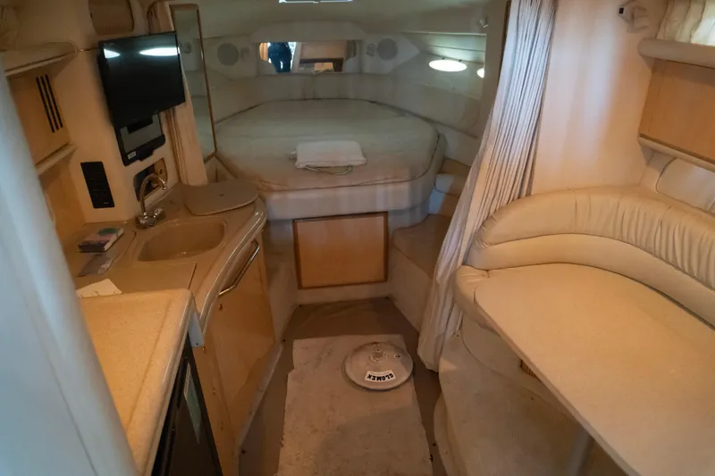 Slide: The Image of 2001 Sea Ray 340 Sundancer cabin interior with bed, kitchenette, and seating area. - 11