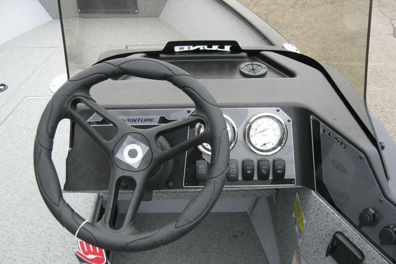 Slide: The Image of 2025 Lund 1775 Adventure SS boat dashboard with steering wheel and gauges. - 11