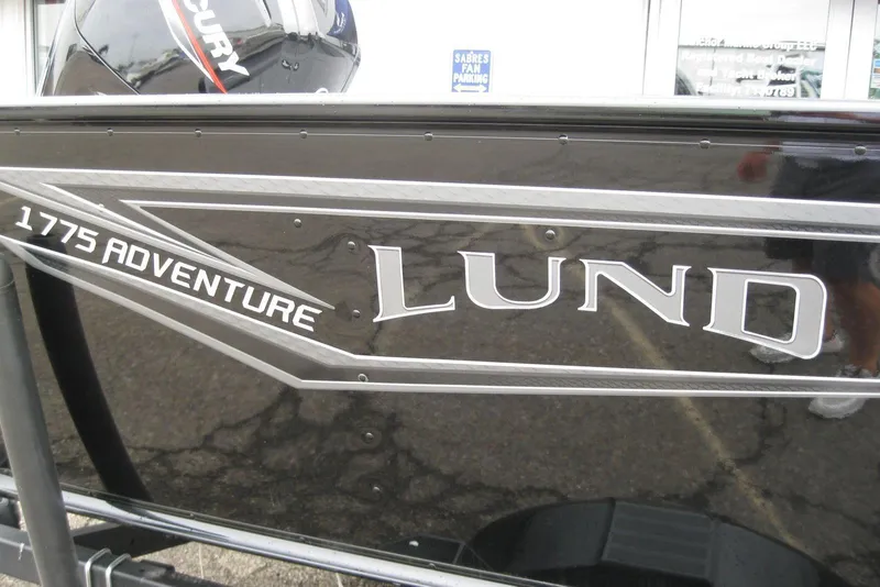 Slide: The Image of 2025 Lund 1775 Adventure SS boat with Mercury engine, close-up view. - 2