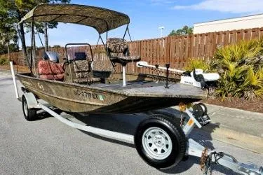 Slide: The Image of 2021 G3 Gator Tough 18 CCJ DLX boat on trailer, camo design, parked outdoors. - 10