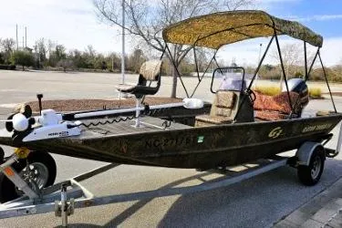Slide: The Image of 2021 G3 Gator Tough 18 CCJ DLX boat on trailer, camo design, parked outdoors. - 8
