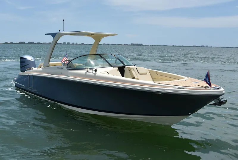 The Image of 2020 Chris-Craft Launch 28 boat cruising on calm water under clear blue sky. - 0