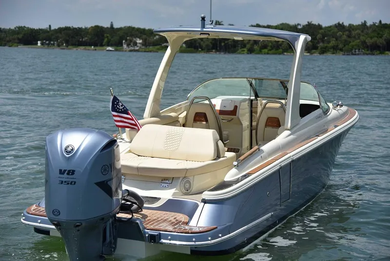 Slide: The Image of 2020 Chris-Craft Launch 28 boat cruising on a sunny day, surrounded by lush greenery. - 1