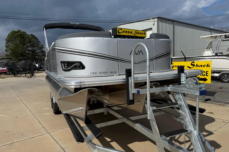 Slide: The Image of 2026 Avalon LSZ Quad Lounge Shift pontoon boat on trailer, displayed outdoors. - 2