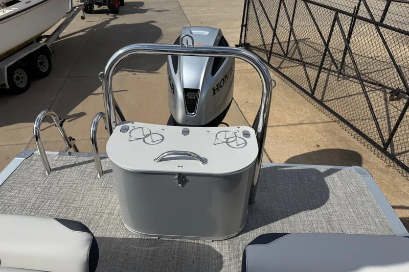 Slide: The Image of 2026 Avalon LSZ Quad Lounge Shift boat with Honda engine, docked on concrete surface. - 36