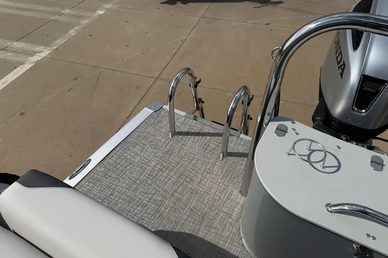 Slide: The Image of 2026 Avalon LSZ Quad Lounge Shift boat with Honda engine, featuring sleek deck and ladder. - 37