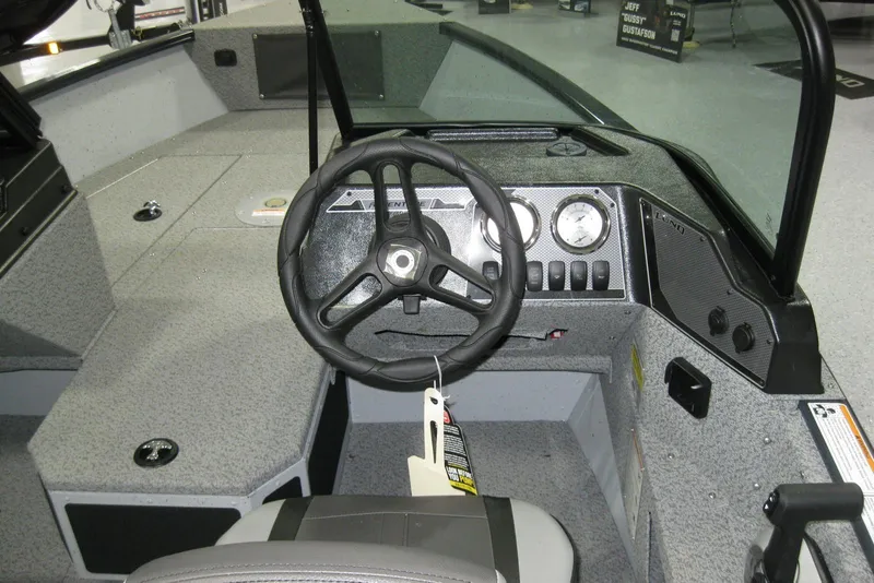 Slide: The Image of 2025 Lund 1775 Adventure Sport boat interior with steering wheel and dashboard controls. - 7