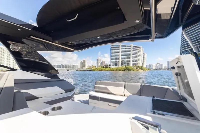 Slide: The Image of 2021 Cruisers Yachts 38 GLS OB on water, city skyline in background. - 23