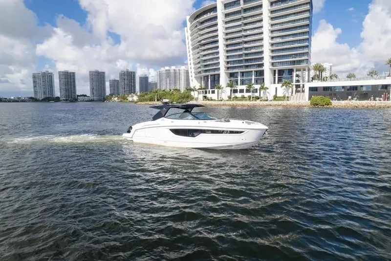 Slide: The Image of 2021 Cruisers Yachts 38 GLS OB on water near modern cityscape. - 9