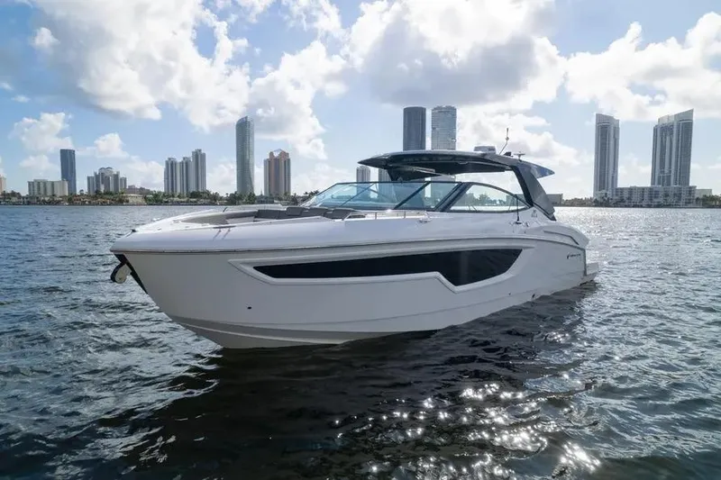 The Image of 2021 Cruisers Yachts 38 GLS OB on water with city skyline background. - 1