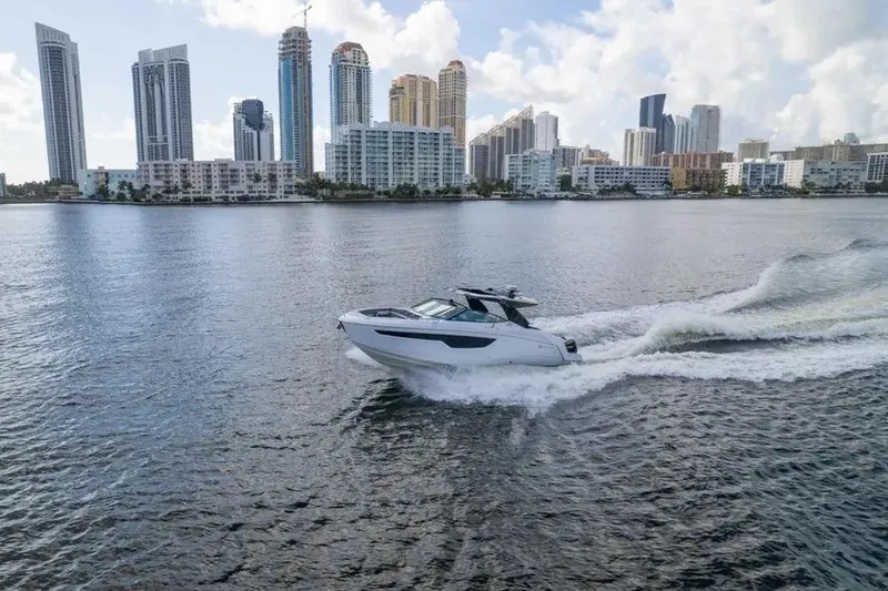 Slide: The Image of 2021 Cruisers Yachts 38 GLS OB cruising near city skyline on a sunny day. - 2