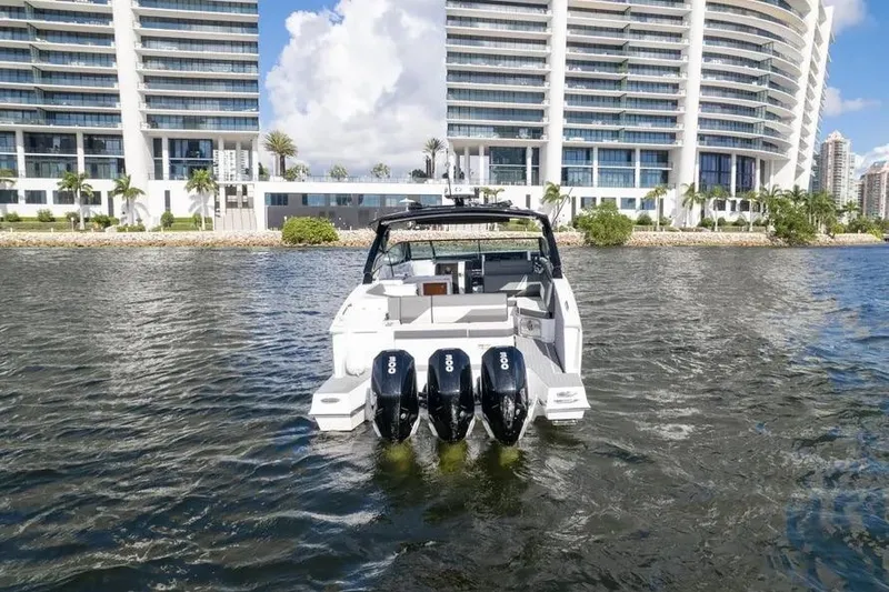 Slide: The Image of 2021 Cruisers Yachts 38 GLS OB on water, with modern buildings in background. - 6
