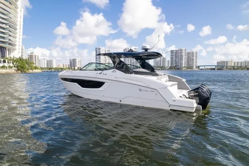 Slide: The Image of 2021 Cruisers Yachts 38 GLS OB on water, city skyline in background. - 7