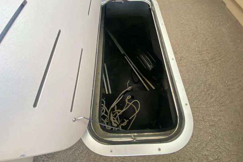 Slide: The Image of Storage compartment on a 2012 Bennington 2575 QCW I/O boat with ropes and equipment. - 12