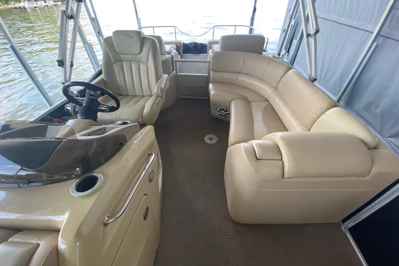 Slide: The Image of Interior of a 2012 Bennington 2575 QCW I/O boat with beige seating and steering console. - 17