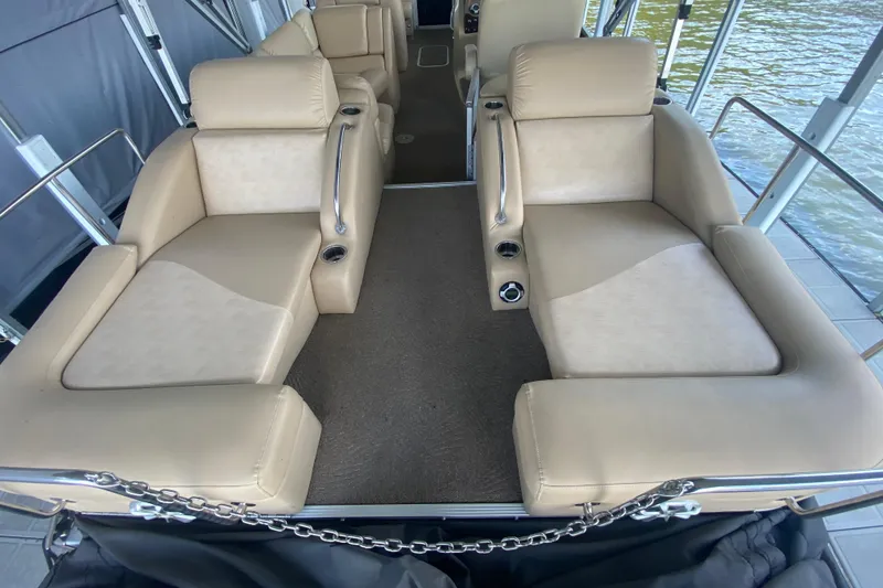 Slide: The Image of 2012 Bennington 2575 QCW I/O boat interior with beige seating and cup holders. - 20