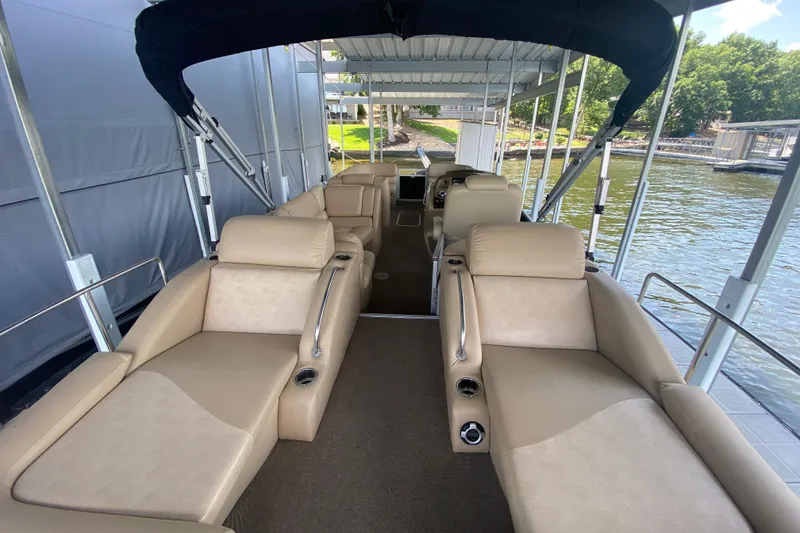Slide: The Image of 2012 Bennington 2575 QCW I/O pontoon boat with beige seating under a canopy. - 21