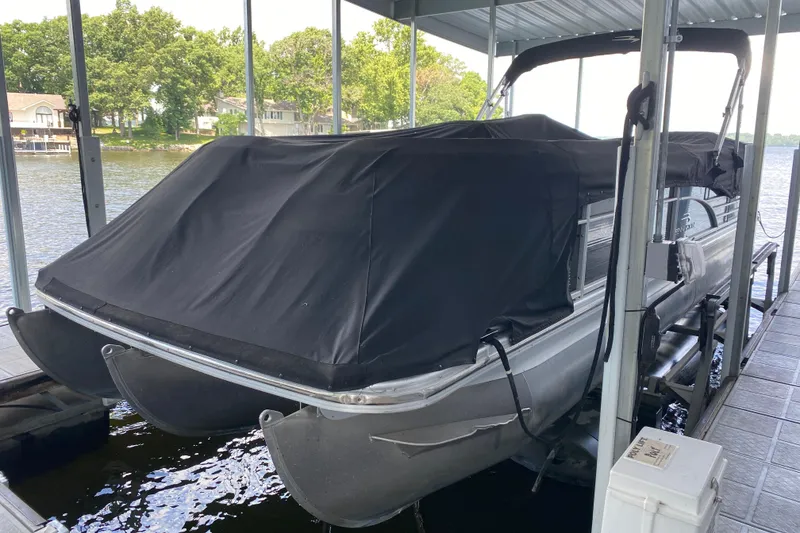 Slide: The Image of 2012 Bennington 2575 QCW I/O pontoon boat covered at dockside. - 27