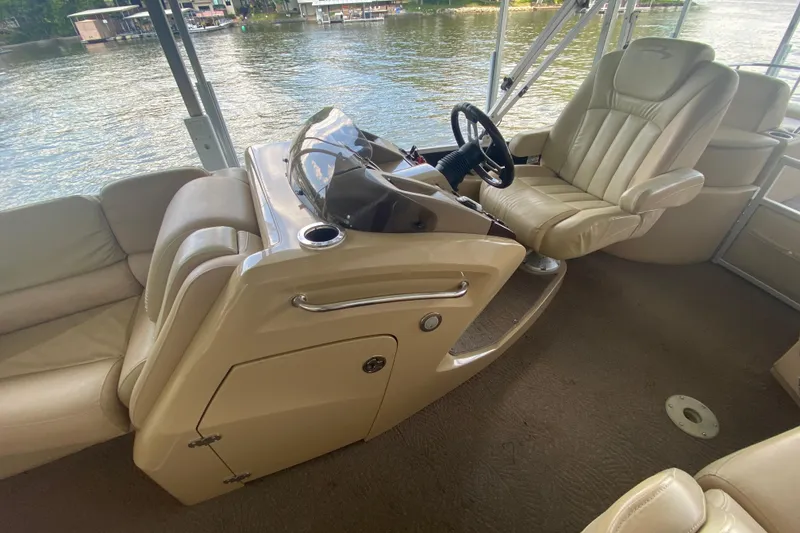 Slide: The Image of Luxurious interior of 2012 Bennington 2575 QCW I/O boat with plush seating and steering console. - 9