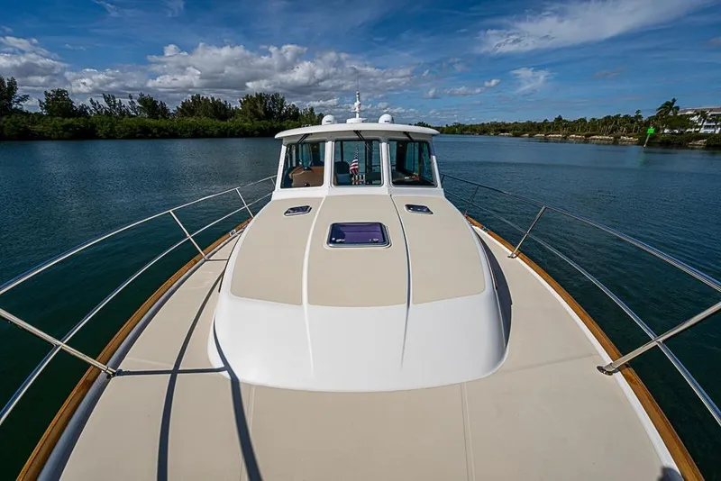 Slide: The Image of 2016 Sabre 42 Salon Express yacht on serene waterway under blue sky. - 10