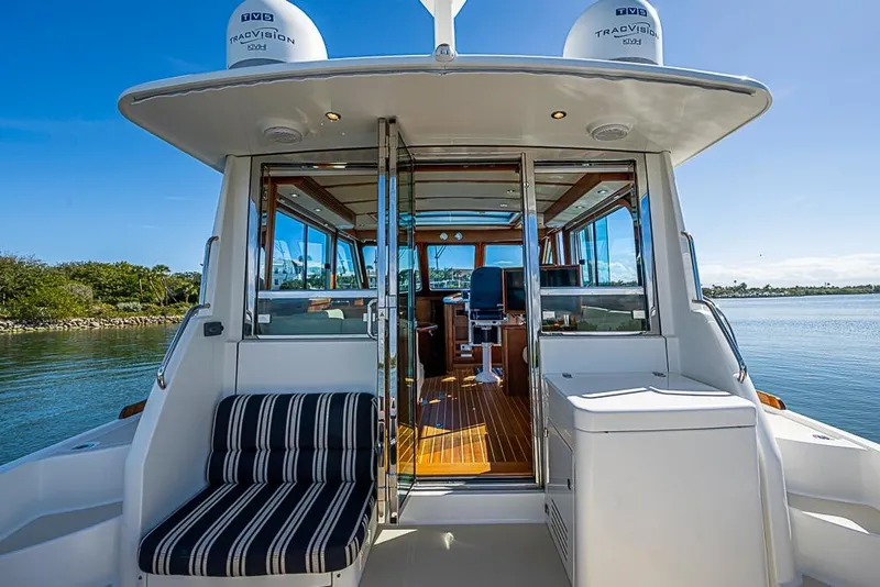 Slide: The Image of 2016 Sabre 42 Salon Express yacht with open cabin, striped seating, and scenic water view. - 12