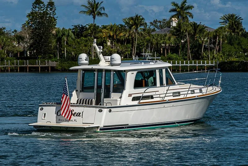 Slide: The Image of 2016 Sabre 42 Salon Express yacht cruising on a scenic waterway with palm trees. - 5