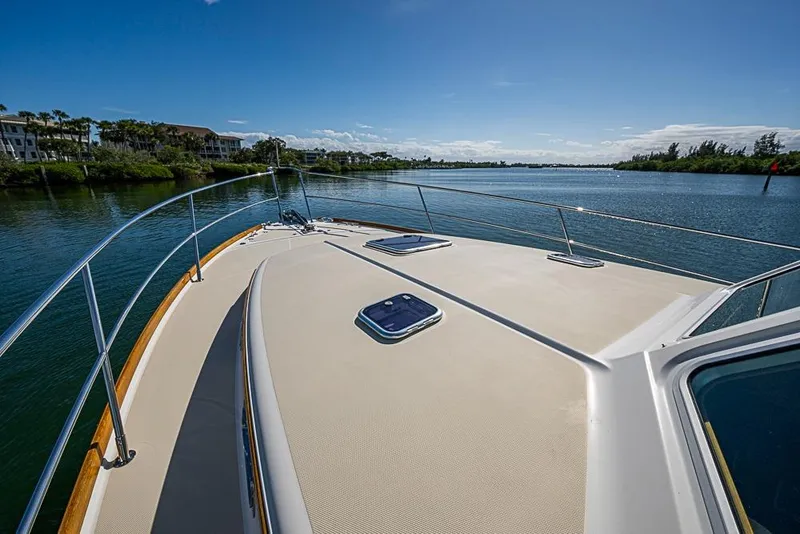 Slide: The Image of 2016 Sabre 42 Salon Express yacht cruising on a scenic waterway under clear blue skies. - 8