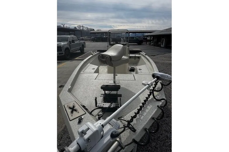 Slide: The Image of 2017 Xpress H20B Bay boat with trolling motor in parking lot. - 2