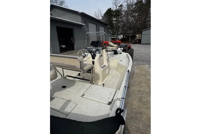 Slide: The Image of 2017 Xpress H20B Bay boat parked near a garage, showcasing its deck and controls. - 9