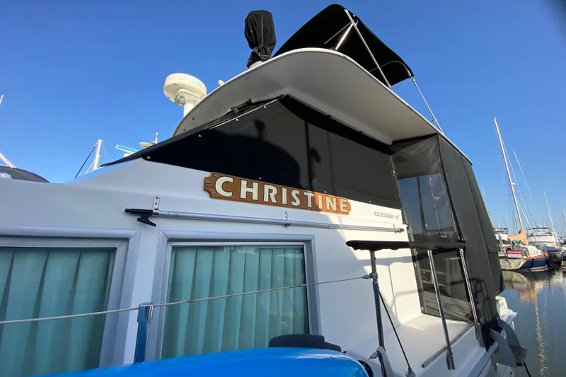 Slide: The Image of 1977 Bertram 42 Flybridge Motor Yacht docked, named "Christine," with clear blue sky background. - 10