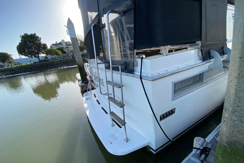 Slide: The Image of 1977 Bertram 42 Flybridge Motor Yacht docked at marina, rear view. - 11