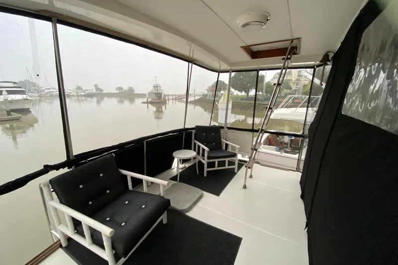 Slide: The Image of 1977 Bertram 42 Flybridge Motor Yacht interior with seating and marina view. - 13