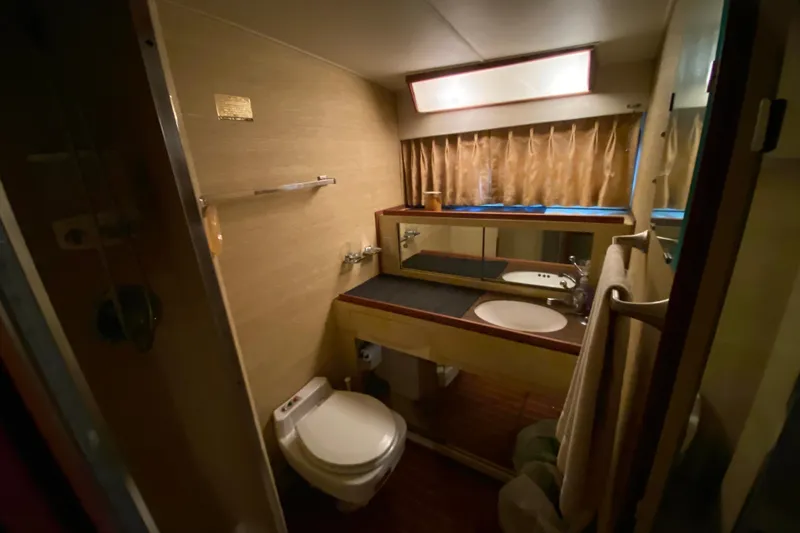 Slide: The Image of 1977 Bertram 42 Flybridge Motor Yacht bathroom with sink, toilet, and mirror. - 21