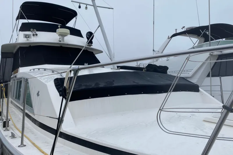 Slide: The Image of 1977 Bertram 42 Flybridge Motor Yacht docked, showcasing sleek design and spacious deck. - 25