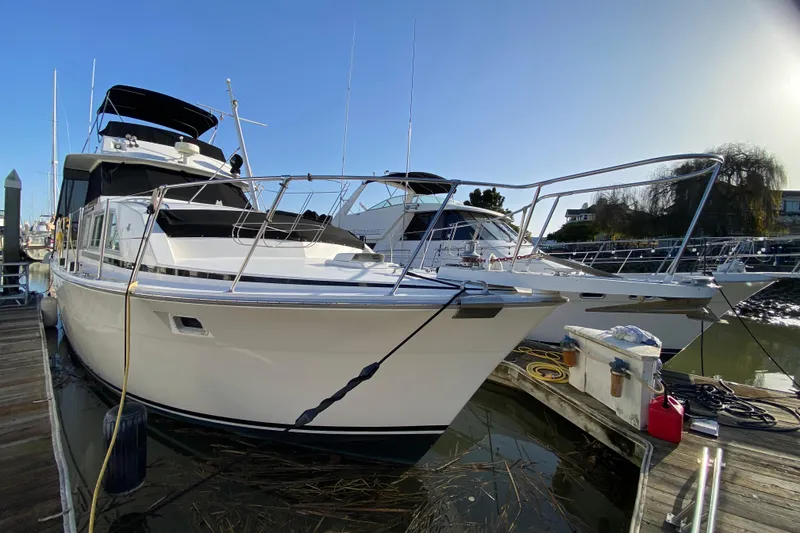 Slide: The Image of 1977 Bertram 42 Flybridge Motor Yacht docked at marina under clear blue sky. - 6