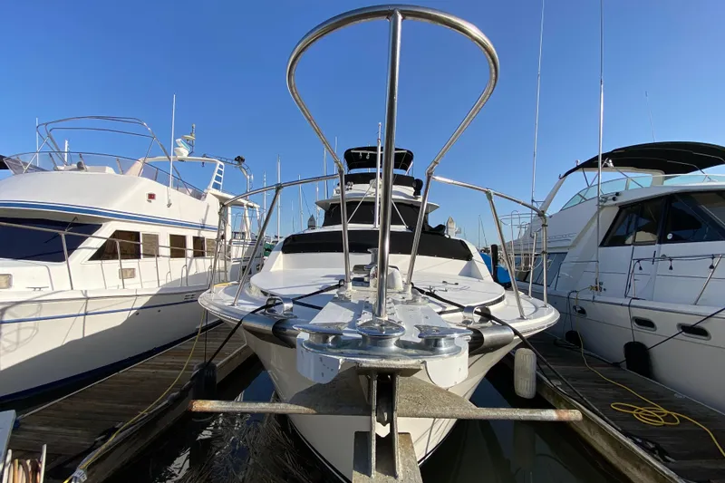 Slide: The Image of 1977 Bertram 42 Flybridge Motor Yacht docked between other boats. - 7