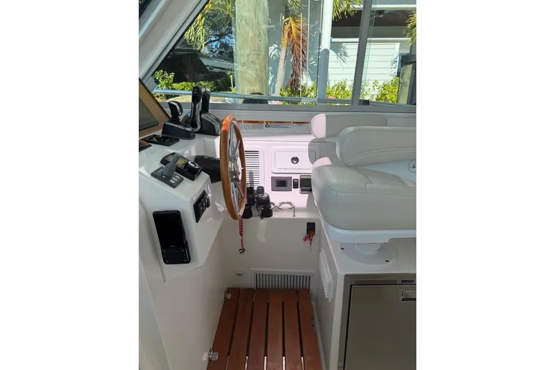 Slide: The Image of 2023 Back Cove 340 helm with wooden steering wheel and modern controls. - 12