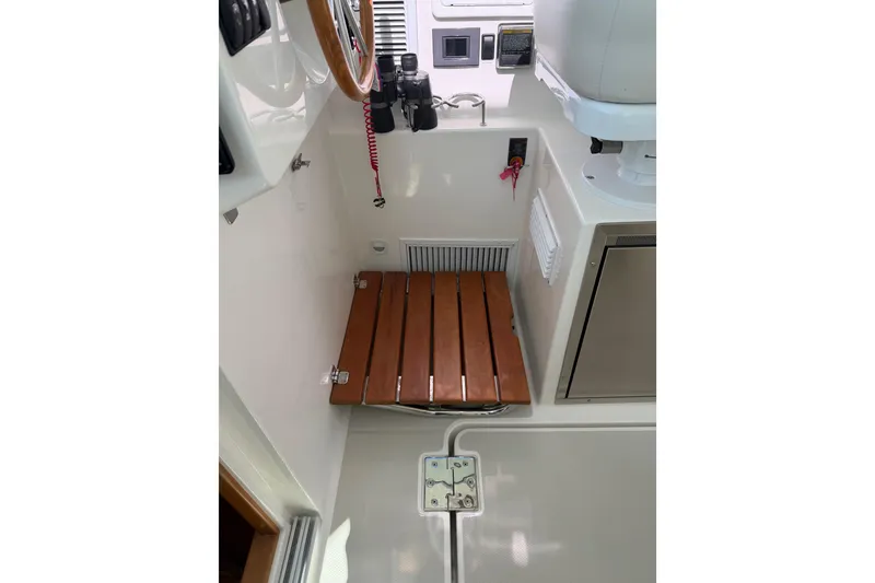 Slide: The Image of 2023 Back Cove 340 interior with wooden seat and control panel. - 13