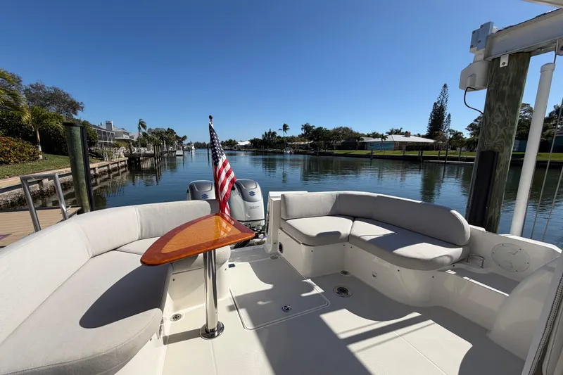 Slide: The Image of 2023 Back Cove 340 boat with seating area and American flag on a sunny day. - 28