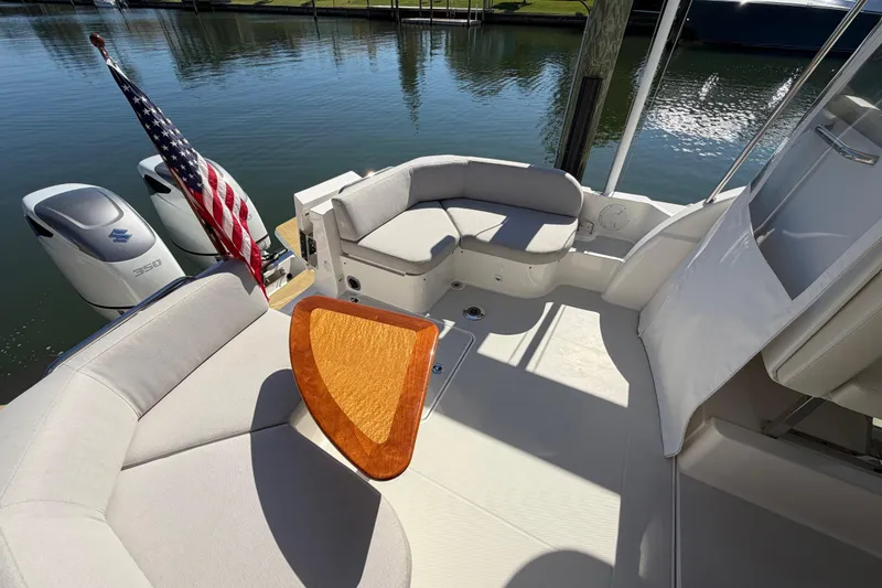 Slide: The Image of 2023 Back Cove 340 boat interior with seating, table, and American flag. - 29
