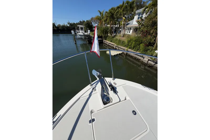 Slide: The Image of 2023 Back Cove 340 boat bow with anchor, docked near waterfront homes. - 32