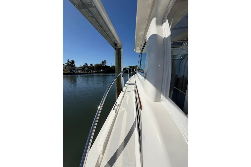 Slide: The Image of 2023 Back Cove 340 yacht docked by calm waters under clear blue sky. - 35