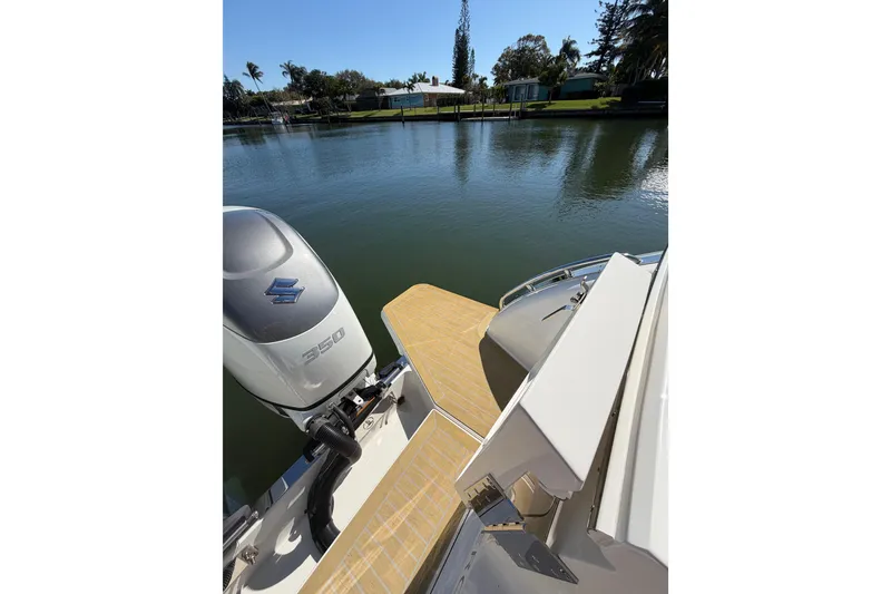 Slide: The Image of 2023 Back Cove 340 boat with Suzuki 350 engine on a serene waterway. - 36