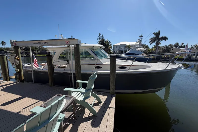 Slide: The Image of 2023 Back Cove 340 boat docked at a sunny marina with palm trees. - 4