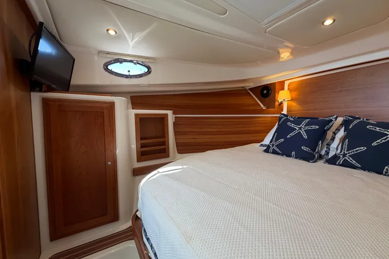 Slide: The Image of Luxurious cabin interior of 2023 Back Cove 340 boat with cozy bedding and elegant wood finish. - 6