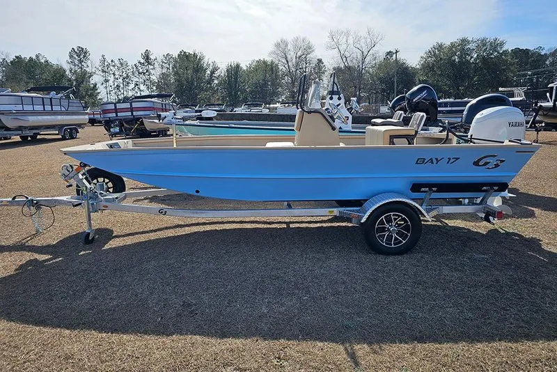 Slide: The Image of 2026 G3 Bay 17 boat on trailer, displayed outdoors with other boats. - 1