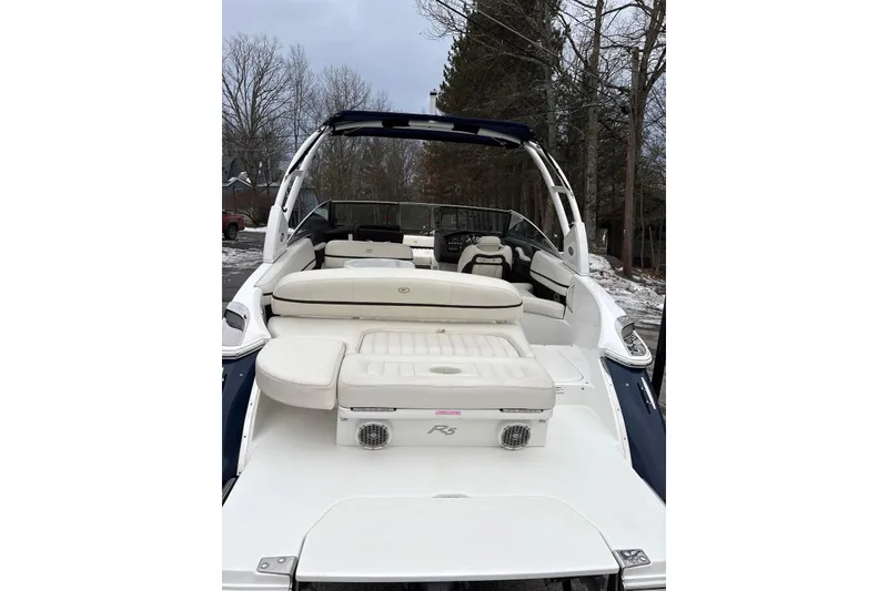 Slide: The Image of 2015 Cobalt R5 boat with white seating, parked outdoors in a wooded area. - 13