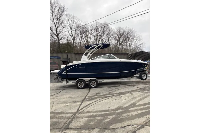 Slide: The Image of 2015 Cobalt R5 boat on trailer, parked outdoors, with trees in the background. - 4