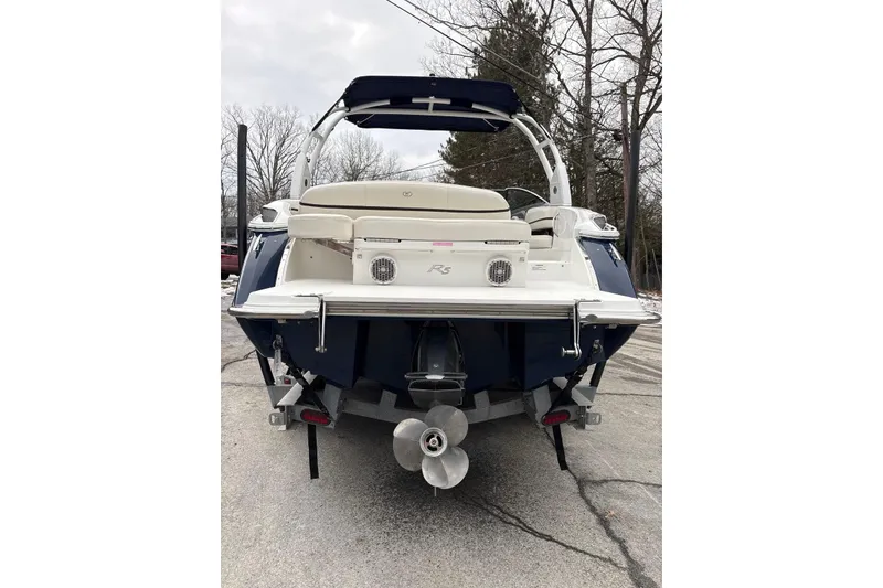 Slide: The Image of 2015 Cobalt R5 boat rear view with propeller and seating, parked on pavement. - 6