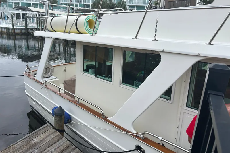 Slide: The Image of 2006 Mariner Orient boat docked, featuring white exterior and deck equipment. - 12